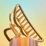 Gold open shape claw clip by KITSCH, stylish hair accessory with a sleek, modern design, shown on a neutral background.