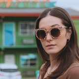 SARDINE Aster Toasted Moxie Round Checkered Sunglasses with black and white checkered pattern, round frames, and tinted lenses.