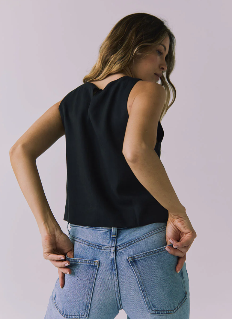 Chaser Riley black top shown on a woman, featuring a stylish sleeveless design with a round neckline and fitted silhouette.