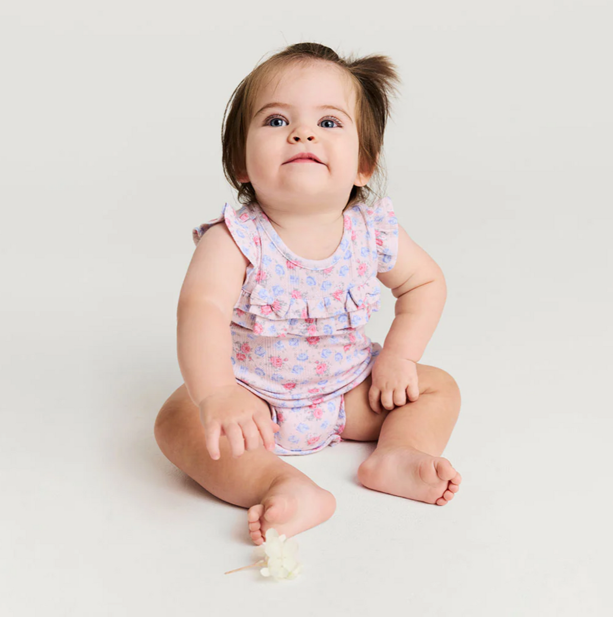 Baby girl pointelle ruffled bubble romper by Posh Peanut with delicate ruffles and a soft, breathable fabric.