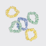 Set of five KITSCH ruched satin scrunchies in various vibrant colors, displayed on a soft fabric background.