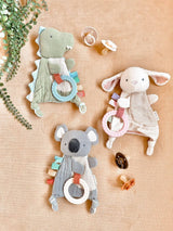 Itzy Ritzy Bitzy Crinkle Sensory Toy with Teether in dinosaur shape, soft fabric with crinkle textures for sensory play.