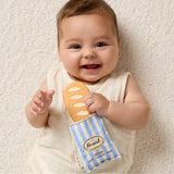 Itzy Ritzy Baguette Teensy Crinkle diaper bag in soft pink with textured crinkle fabric and sleek compact design.