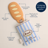 Itzy Ritzy Baguette Teensy Crinkle tote bag with crinkled fabric and compact design, perfect for stylish everyday use.