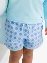 Boys periwinkle blue coastal cane performance hybrid dolphin hem swim trunks in size 18-24 months with ruffle accents.