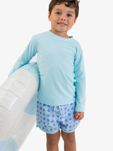 Boys periwinkle blue Coastal Cane hybrid dolphin hem swim trunks by RuffleButts + RuggedButts, featuring a comfortable fit and vibrant color.