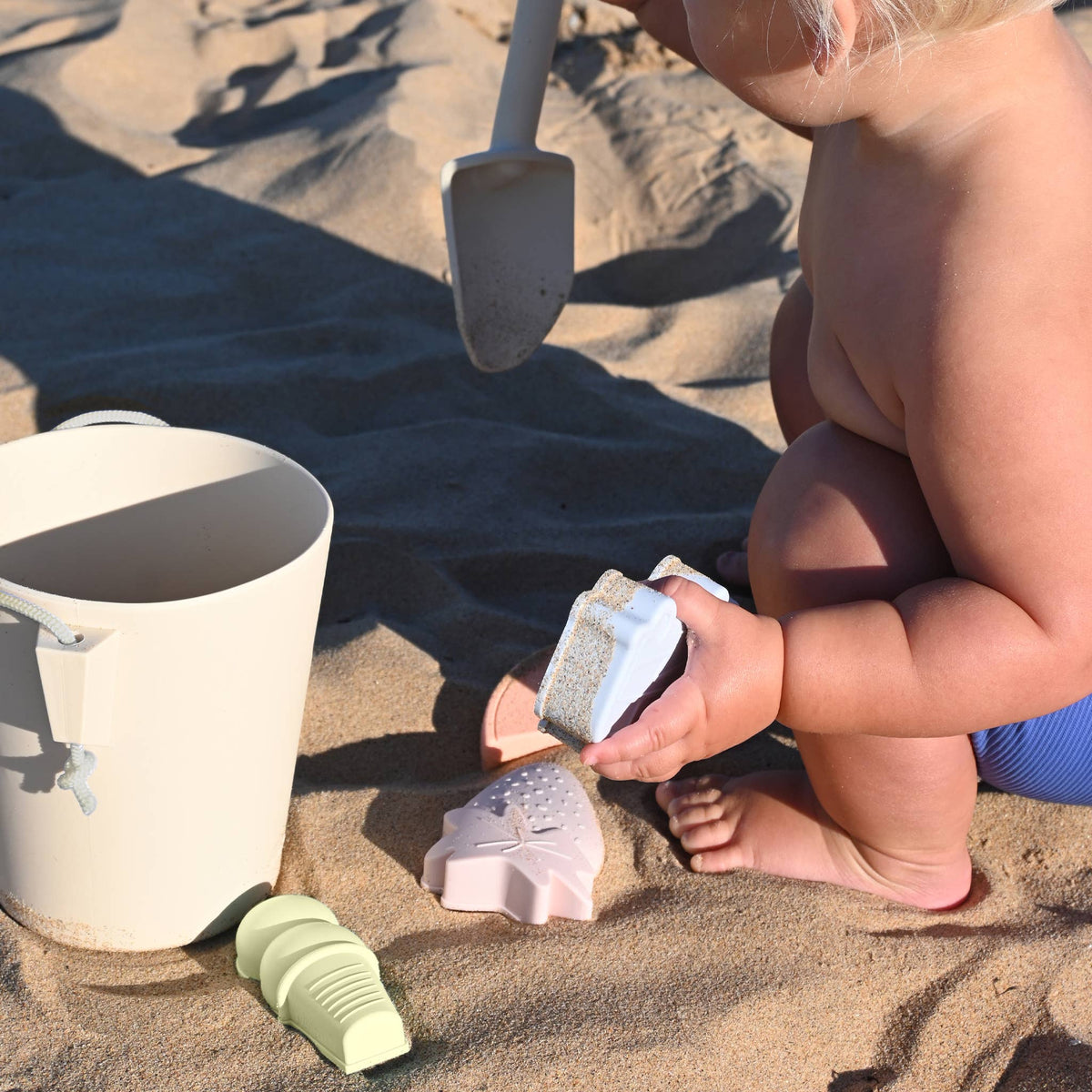 Sunnylife silicone bucket and spade set in apple sorbet multi, perfect for kids' beach play and sandcastle building.