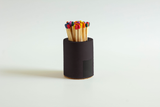 Black and rainbow cylinder match holder by Tenn Prairie with a sleek, modern design for safe and stylish match storage.