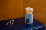 Black and rainbow-colored cylinder match holder by Tenn Prairie, featuring a sleek, modern design for storing matches.