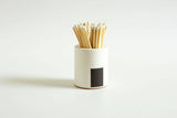 Black and rainbow-colored cylinder match holder by Tenn Prairie, with a sleek, modern design for storing matches.