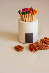 Black and rainbow-colored Tenn Prairie Cylinder Match Holder with a sleek, modern design for safe and stylish match storage.