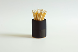 Black and rainbow cylinder match holder by Tenn Prairie with a sleek, modern design for safe and convenient match storage.