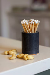 Black and rainbow-colored cylinder match holder by Tenn Prairie with a sleek, modern design for safe match storage.
