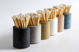 Black and rainbow cylinder match holder by Tenn Prairie with a sleek, modern design for safe and stylish match storage.