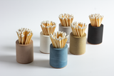 Black and rainbow cylindrical match holder by Tenn Prairie, featuring a sleek design for storing matches.