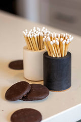 Black and rainbow-colored cylinder match holder by Tenn Prairie, featuring a sleek design and decorative rainbow accents.