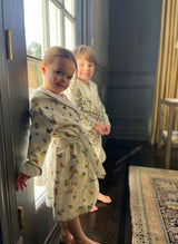White Madame Butterfly bathrobe for 1-2 year-olds by Timo & Violet, soft and cozy with a gentle floral design.