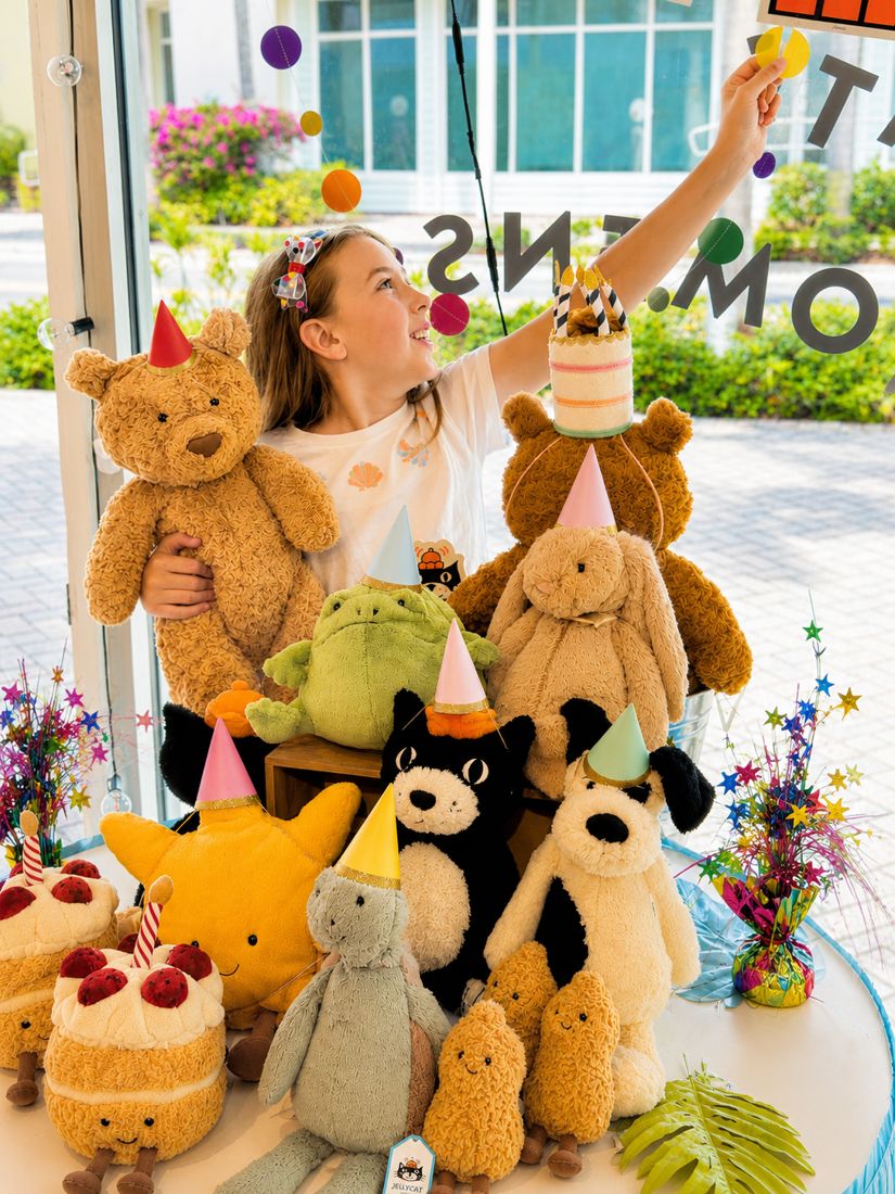 Girl celebrating with Jellycat plush toys in party hats