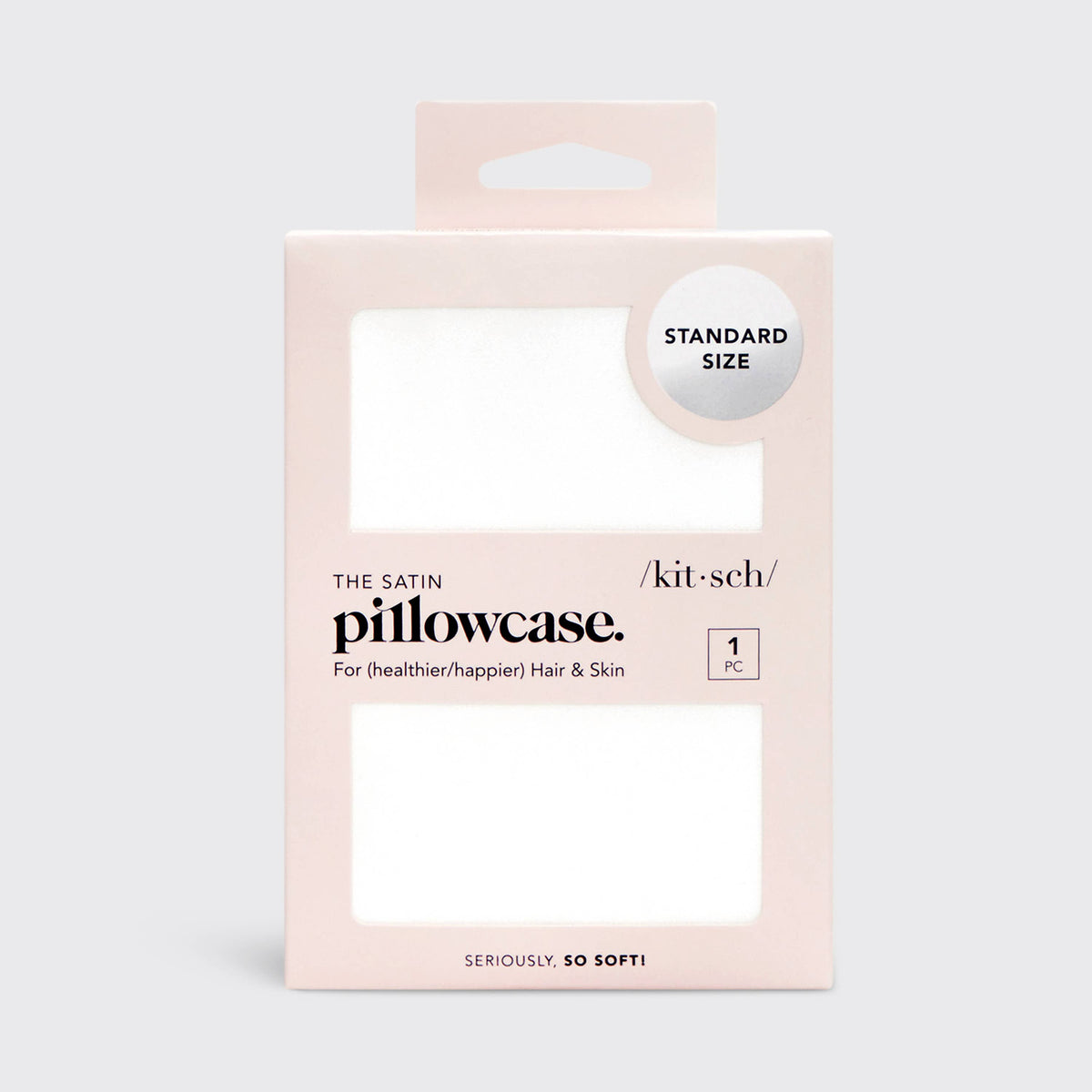 Ivory satin pillowcase by KITSCH featuring smooth, shiny fabric and a neatly sewn edge on a bed.